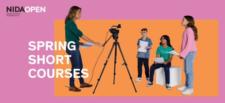 A woman directing kids acting, she stands behind a film camera