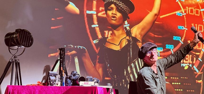 Tony Mott on stage discussing his photograph of pop star Rhianna