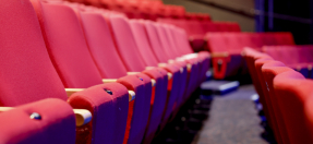 A row of empty red theatre chairs
